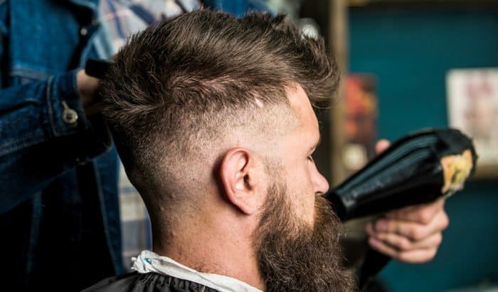 barber blow drying a mans beard