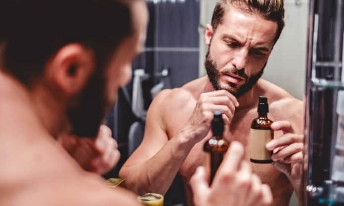 man looking at beard oil ingredient label man looking at beard oil ingredient label
