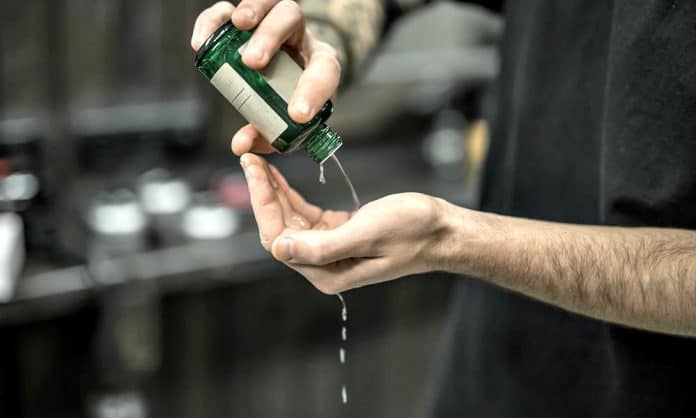 man pouring beard growth product on his hand