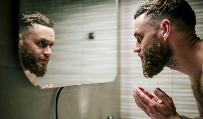 man scrubbing his beard